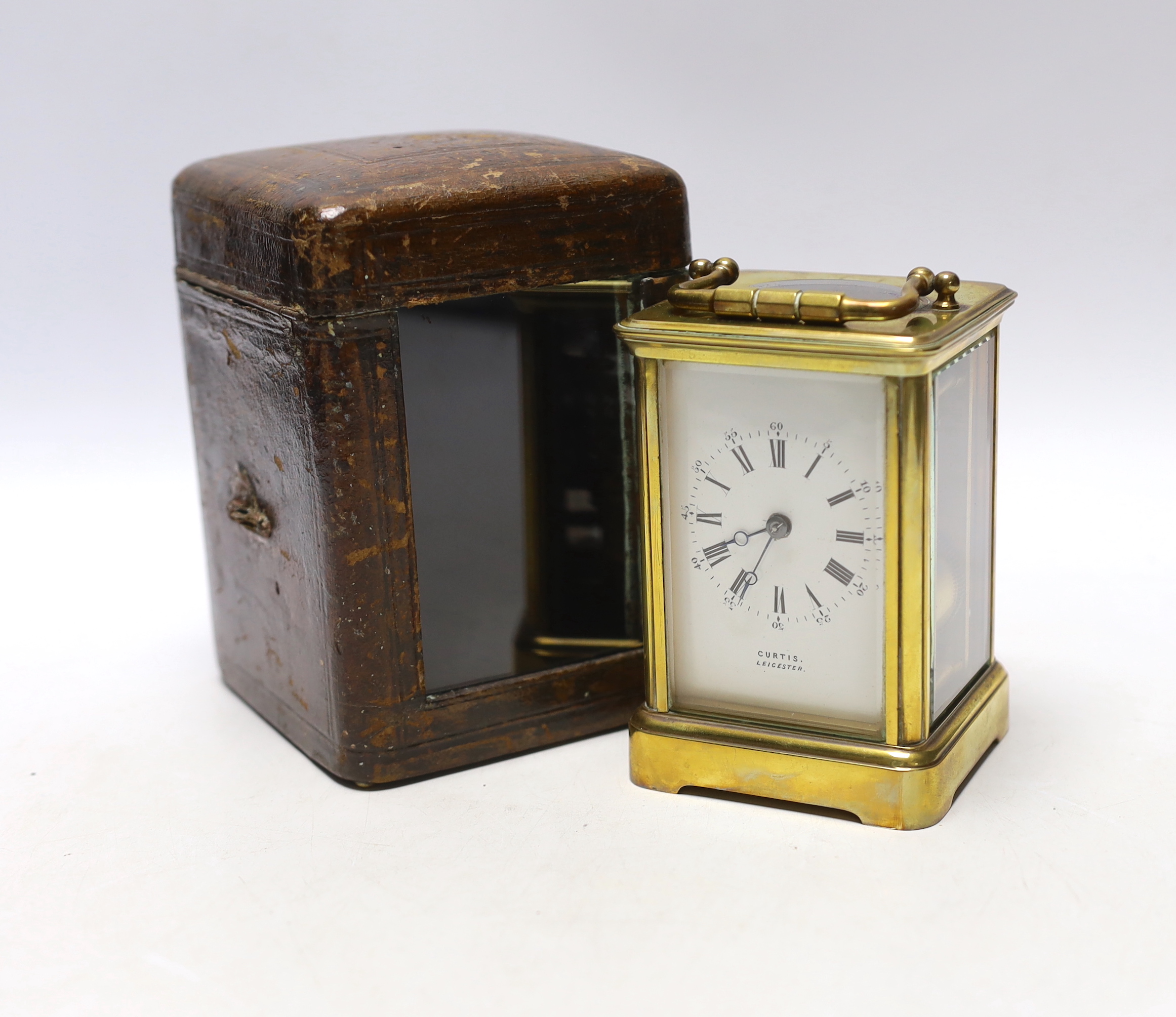 A Curtis brass carriage timepiece, in leather case, 15cm high